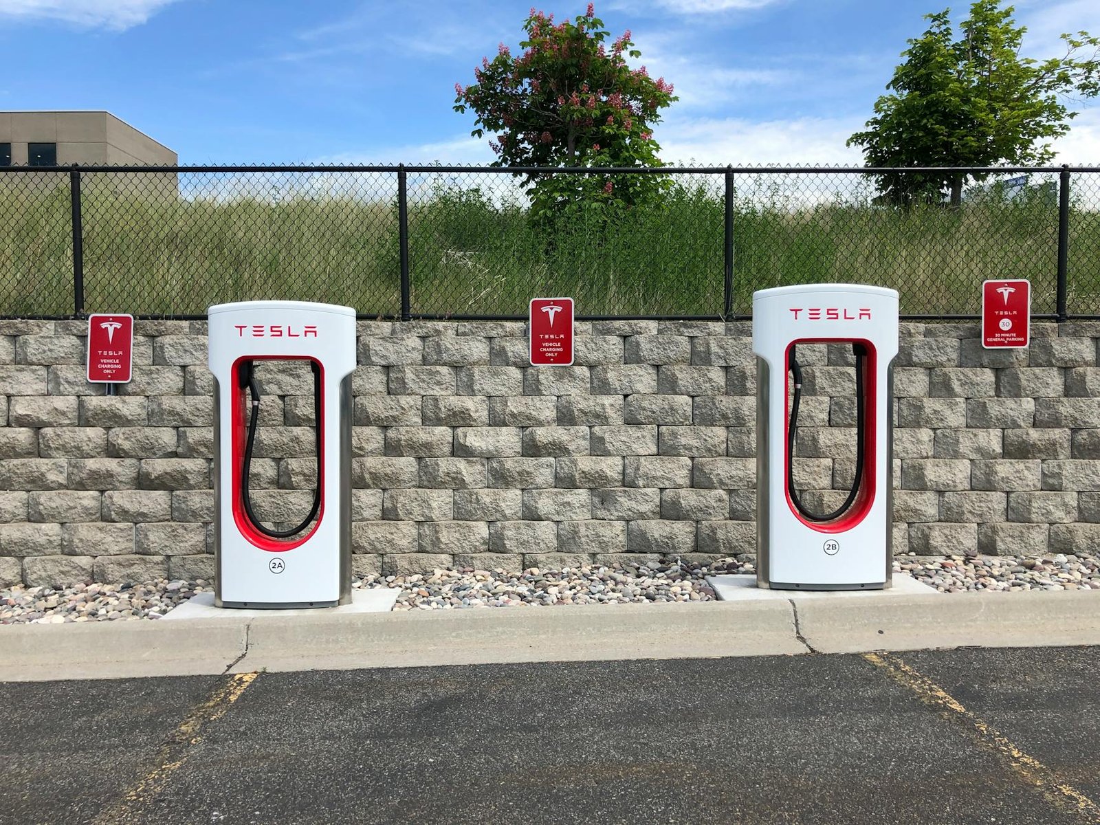 Double chargeurs de voitures électriques Tesla dans le parking de l'Idaho Falls avec un ciel bleu clair.