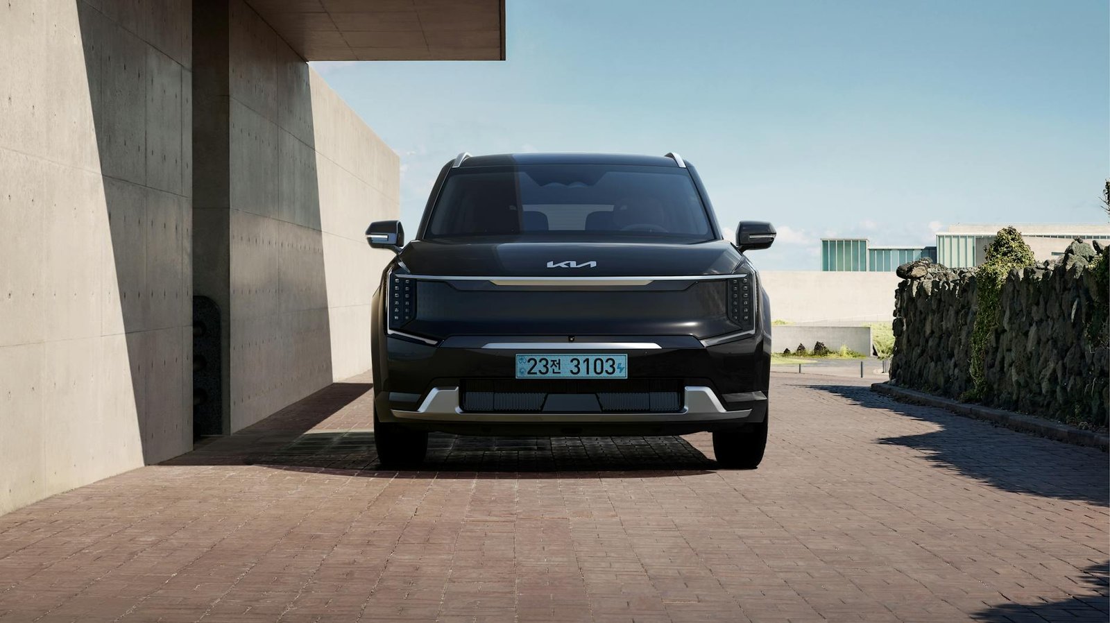 SUV électrique noir élégant stationné dans un environnement architectural contemporain.