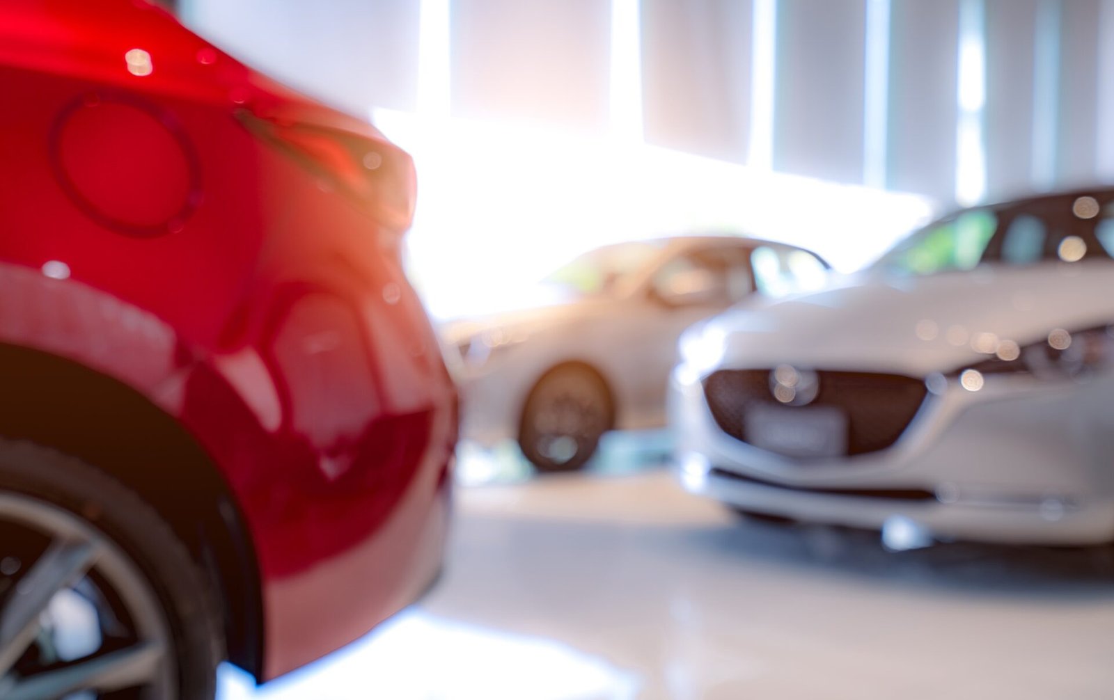 Foulé d'une voiture de luxe blanche et rouge garée dans une salle d'exposition moderne. 