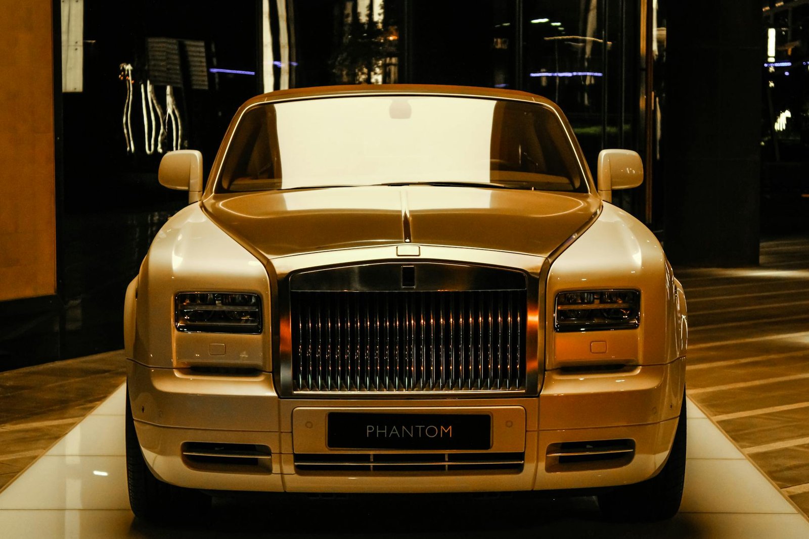 Vue avant d'un luxueux fantôme en or Rolls-Royce exposé dans une salle d'exposition de Dubaï.