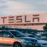 L'usine Tesla avec des voitures garées pendant le coucher du soleil, présentant des vibrations modernes de l'industrie automobile.