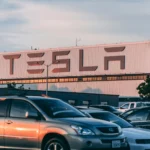 L'usine Tesla avec des voitures garées pendant le coucher du soleil, présentant des vibrations modernes de l'industrie automobile.