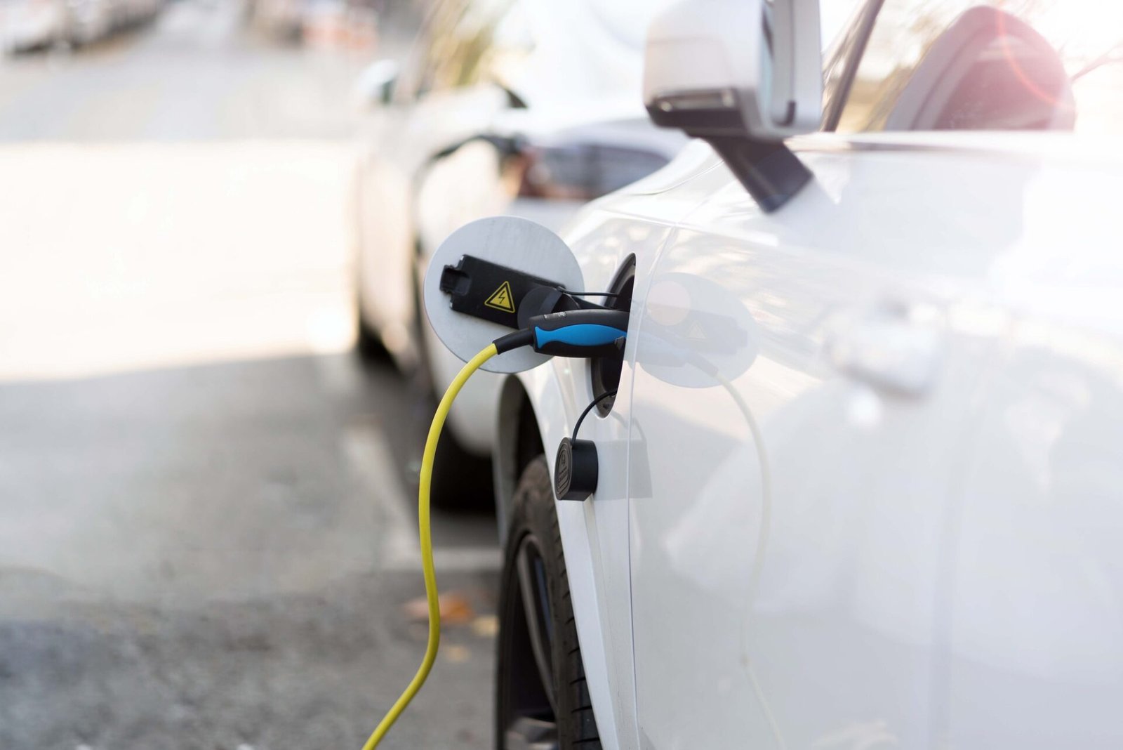 Voiture EV ou voiture électrique à la station de charge avec le connecteur du câble d'alimentation de nature floue avec un fond de lumière douce. 