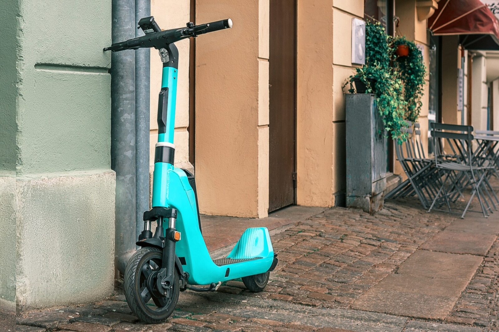 Scooter électrique bleu garé dans une rue de la ville. 