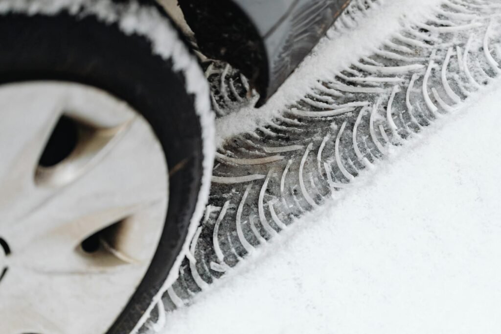 Une vue détaillée des traces de pneus de véhicule sur une route enneigée pendant l'hiver.