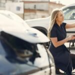 Une femme recharge sa voiture électrique dans une gare municipale, adoptant un voyage respectueux de l'environnement.
